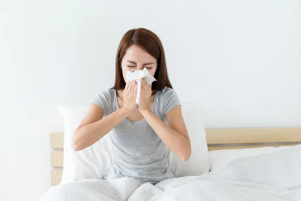 Mujer asiática estornudando en la cama — Foto de Stock