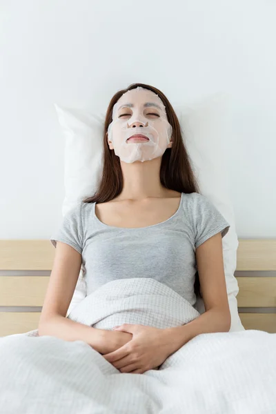 Asiatico donna su letto utilizzando maschera — Foto Stock