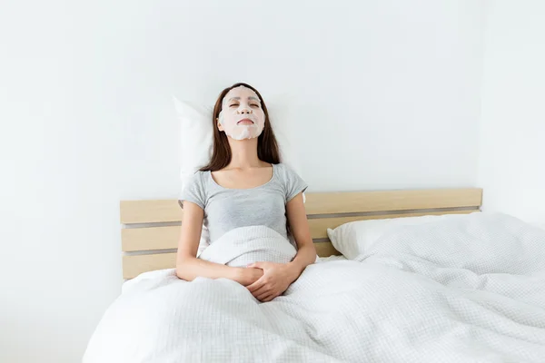 Mujer asiática en la cama usando máscara — Foto de Stock