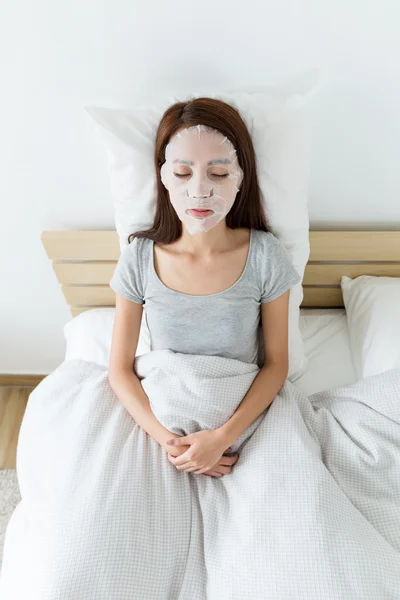 Mujer asiática en la cama usando máscara — Foto de Stock