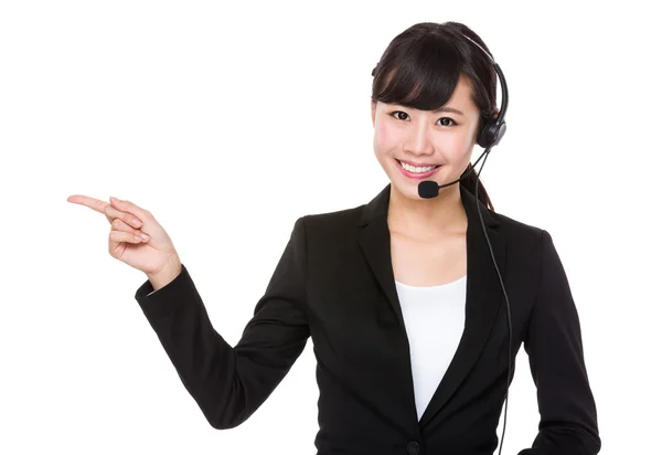 Mujer de negocios con auriculares y el dedo señalando a un lado —  Fotos de Stock