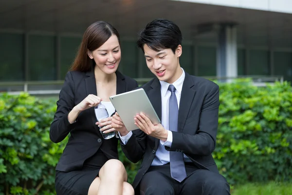 Empresária lendo algo no tablet com empresário — Fotografia de Stock