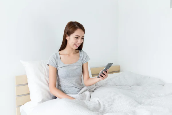 Aziatische jonge vrouw op het bed — Stockfoto