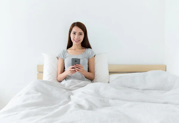 Aziatische jonge vrouw op het bed — Stockfoto