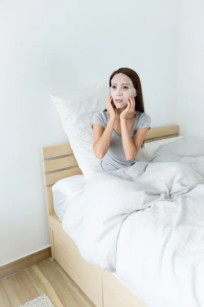 Mujer hacer mascarilla facial en la cama — Foto de Stock