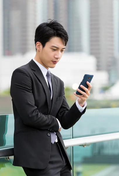 携帯電話でアジア系のビジネスマン時計 — ストック写真
