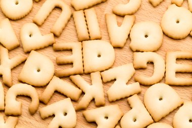 Baked word biscuit over wooden table