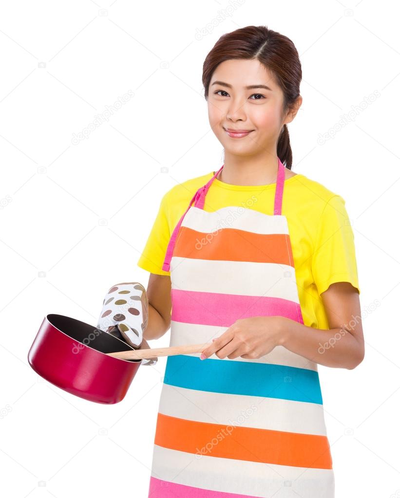 Young Housewife cooking with saucepan
