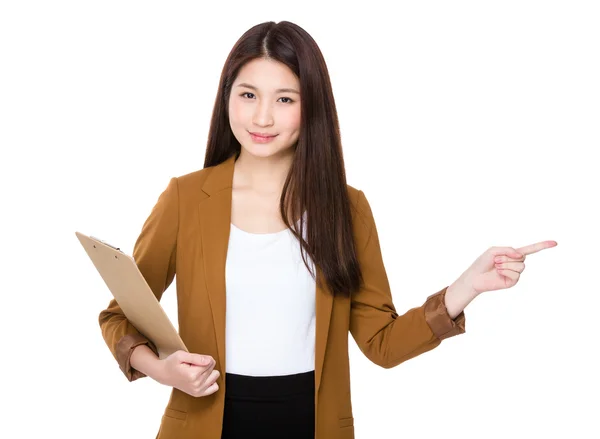 Young businesswoman holding clipboard and finger point away — Stock fotografie