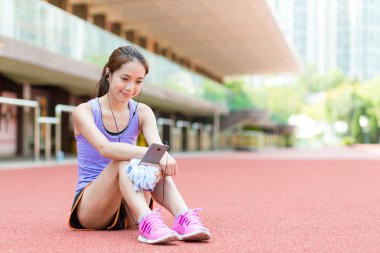 Stadyum üzerinde oturan ve müzik kadın