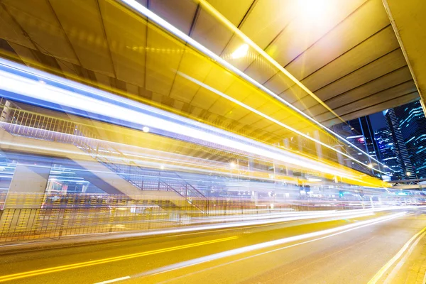 Carro em movimento rápido à noite na cidade moderna — Fotografia de Stock