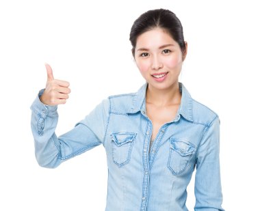 Başparmağını gösteren genç bir kadın.