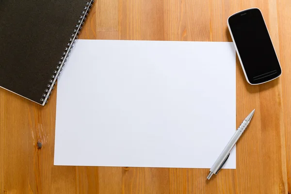 Paper on desk with cellphone for adding information — Stock Photo, Image