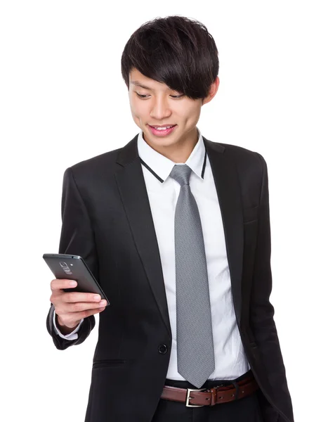 Бизнесмен смотрит на мобильный телефон — стоковое фото