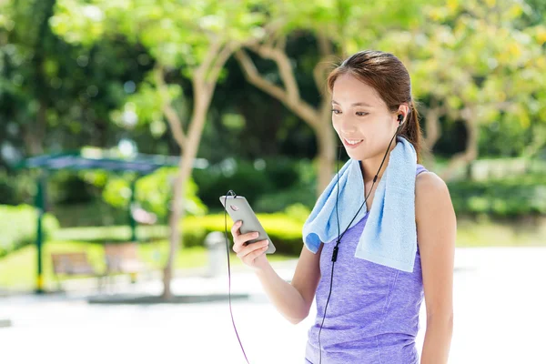 运动女孩用听音乐智能手机 — 图库照片