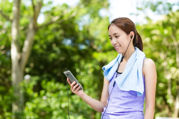 Aziatische vrouw met cellphone luisteren naar muziek — Stockfoto