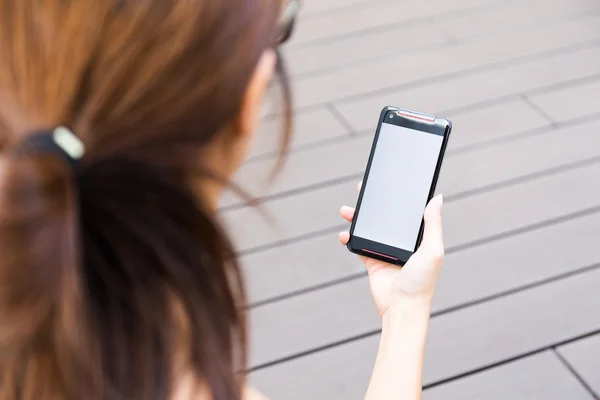 Kvinnan håller en cellphone med blank skärm — Stockfoto