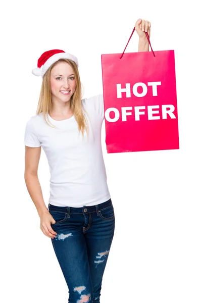 Женщина в рождественской шляпе с бумажным пакетом — стоковое фото