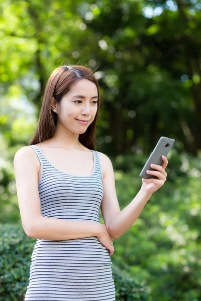 Frau benutzt Handy im Park — Stockfoto