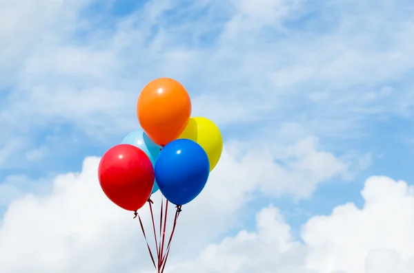 Färgglada ballonger i blå himmel — Stockfoto