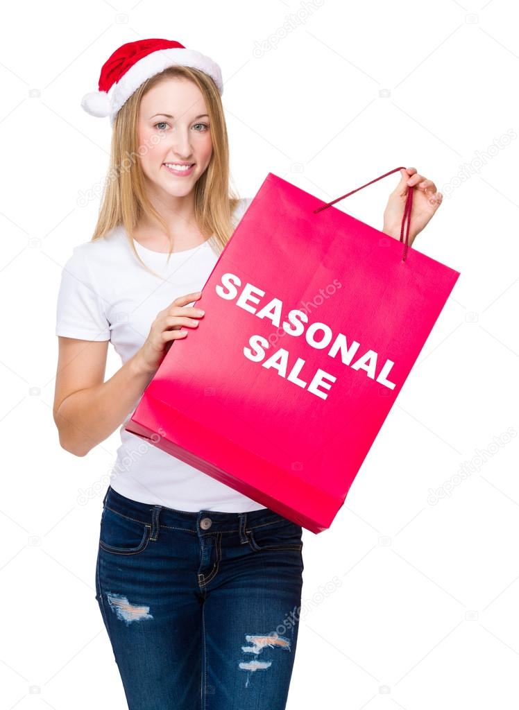 Woman in santa hat with shopping bag