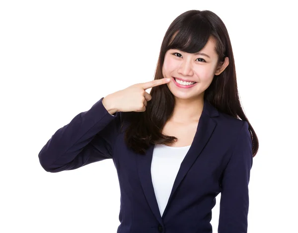 Молодая предпринимательница, указывающая на зубы — стоковое фото