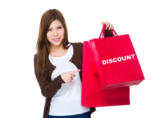 Mujer joven señalando bolsas de compras —  Fotos de Stock