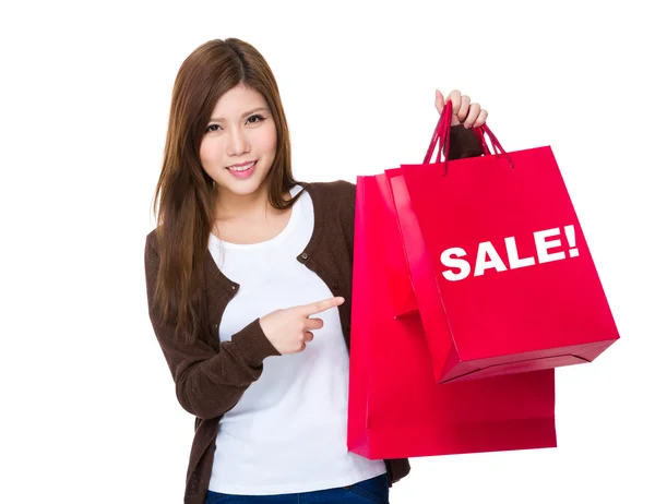 Mujer joven señalando bolsas de compras —  Fotos de Stock