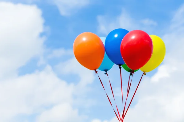 Färgglada ballonger i blå himmel — Stockfoto