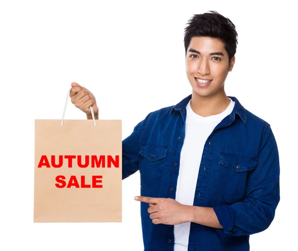 Mann zeigt mit dem Finger auf Einkaufstasche, um Satz des Herbstschlussverkaufs zu zeigen — Stockfoto