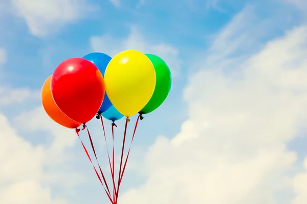 Färgglada ballonger i blå himmel — Stockfoto