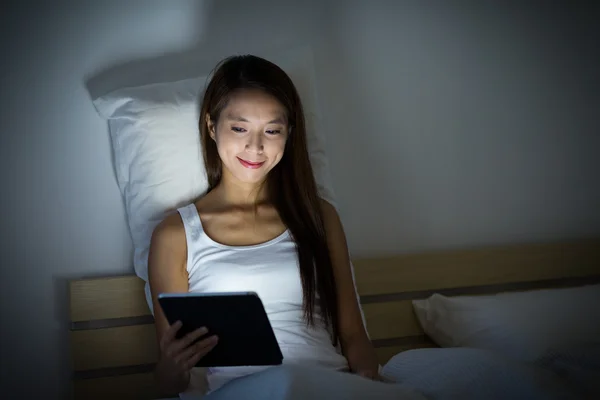 Frau mit digitalem Tablet im Bett — Stockfoto