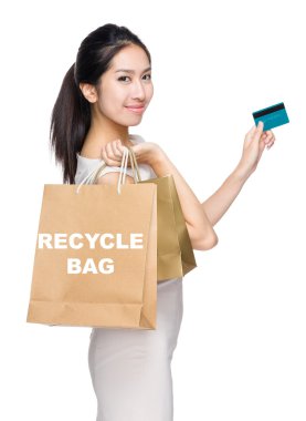 Kredi kartı ve alışveriş çantası olan bir kadın.