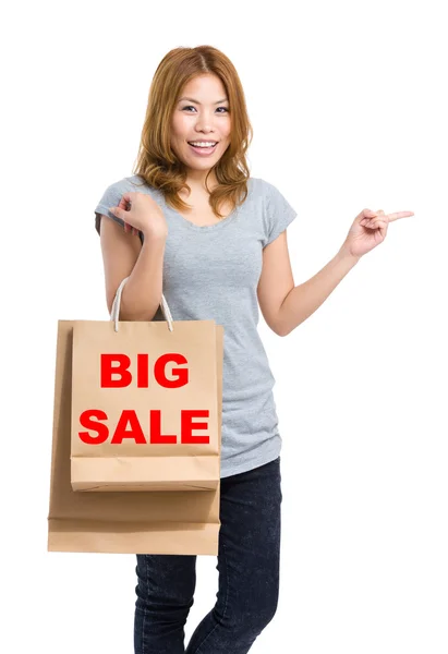 Woman point aside with shopping bags — Stock Photo, Image