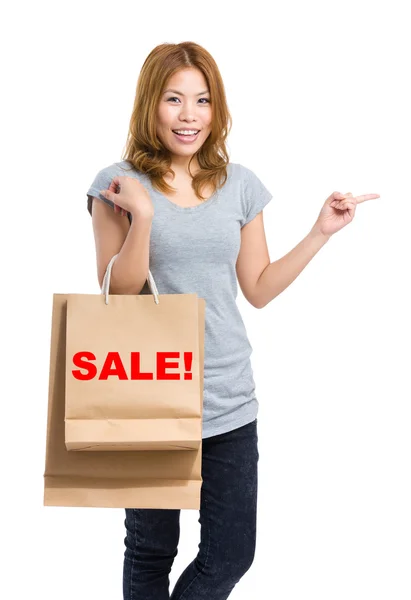 Woman point aside with shopping bags — Stock Photo, Image