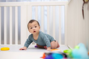 Evde güvenli oyun parkında oynayan sevimli bir bebek.