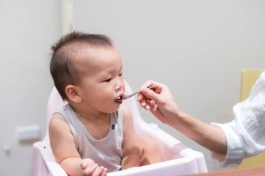 Genç anne, yoğun restoranda bebeğini sabırla besliyor.