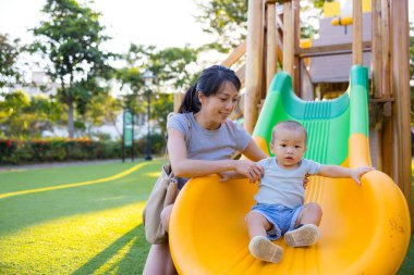 Anne parkta bebeğiyle oynuyordu.