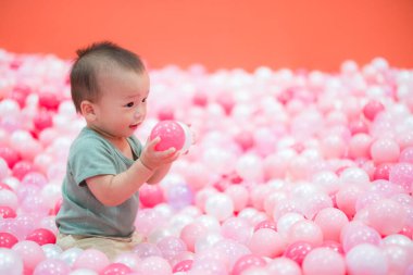 Küçük bebek bilardoda top oynuyor.