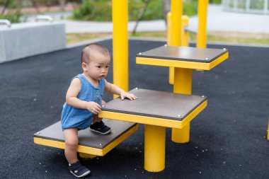 Küçük bebek parkta sürünüyor ve gülümsüyor.