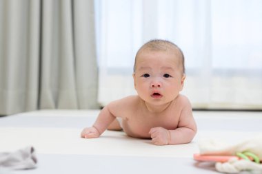 Evde yeni doğmuş bebek yumuşak paspasın üzerinde sürünüyor