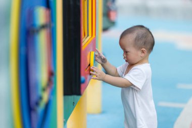 Küçük oğlum dışarıda oyun bahçesinde mutlu mesut oynuyor.