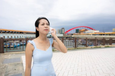 Dışarıdaki teri çıkarmak için doku kullanan genç bir kadın.