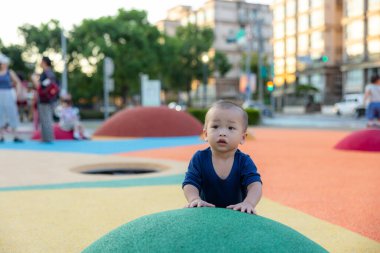 Bebek çocuk renkli oyun bahçesinde mutlu bir şekilde oynuyor.