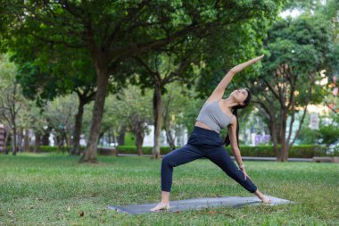Kadın ters savaşçı iki yoga pozisyonu uyguluyor.