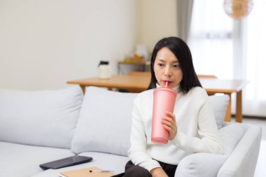 Evdeki şişeden su içen kadın.