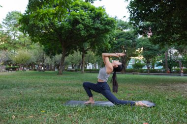 Hilal yogası yapan genç bir kadın.