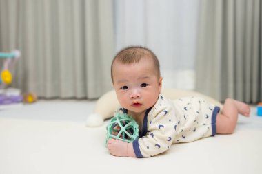 Yerde renkli oyuncaklarla oynayan sevimli bir bebek.