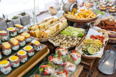 Suşi ve salata fincanlarıyla renkli büfe masası.