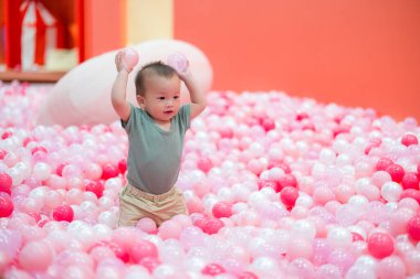 Sevimli bebek oturup bilardo oynuyor.